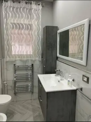 a bathroom with a sink and a mirror and a toilet at La casetta dei limoni in Palermo