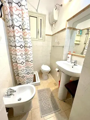 a bathroom with a sink and a toilet and a shower curtain at NONNA MARI' in Palermo