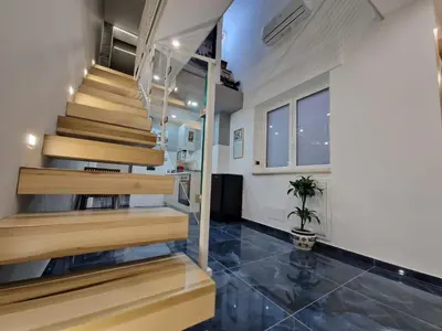 a house with wooden stairs and a potted plant at Confort Home 73 in Palermo