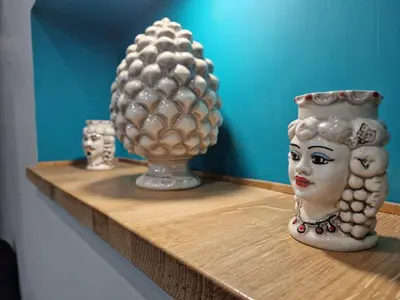 two vases and a statue on a shelf at Confort Home 73 in Palermo