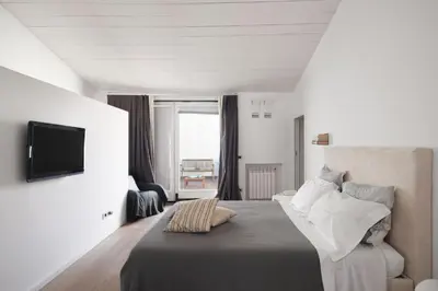 a bedroom with a bed and a tv on a wall at La Cala Terrace by Domusicily in Palermo