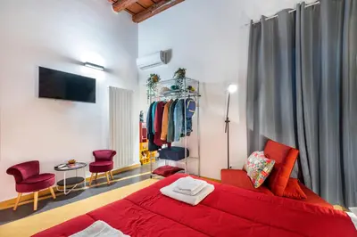 a bedroom with a red bed and some chairs at CASA FLORIO in Palermo