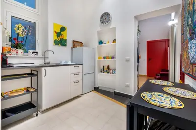a kitchen with white cabinets and plates on the counters at CASA FLORIO in Palermo