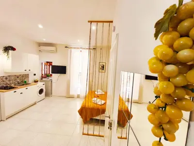 a living room with a kitchen with a table and a kitchen at Sicula Liz & Lulù in Palermo