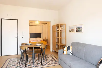 a living room with a couch and a table and a bed at Piricù Apartments in Castellammare del Golfo