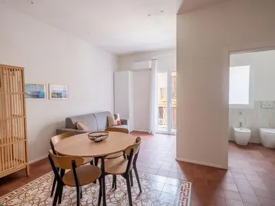 a living room with a table and chairs and a couch at Piricù Apartments in Castellammare del Golfo