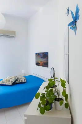 a room with a bed and a table with a plant at Riva Home Il tuo angolo di paradiso in Sicilia ti aspetta! Prenota ora e vivi la magia del Mediterraneo!