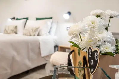 a vase of white flowers on a table next to a bed at Holiday Home GaribaldiOM Palermo Centro Storico! in Palermo