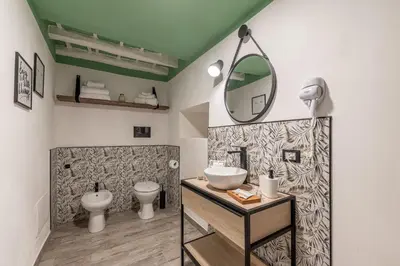 a bathroom with a sink and a toilet and a mirror at Holiday Home GaribaldiOM Palermo Centro Storico! in Palermo
