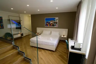 a bedroom with a white bed and a staircase at B&B Maqueda - Room & Suite in Palermo