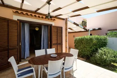 a wooden table and chairs on a patio at Villa Grecale Macari in Macari