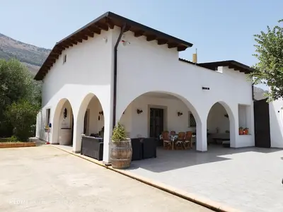 a white building with arches and a patio at Appartamento uso turistico Villa Barbara in Carini