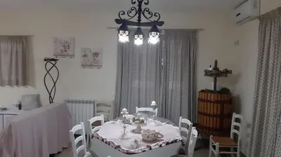 a dining room with a table and a chandelier at Appartamento uso turistico Villa Barbara in Carini