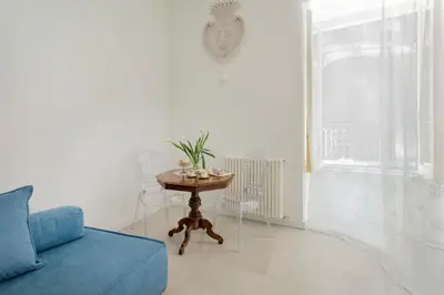 a living room with a blue couch and a table at Palazzo Ventimiglia Lodge & Suites in Palermo