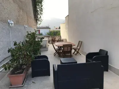 an outdoor patio with chairs and tables and plants at Appartamento Trilocale Mondello in Mondello