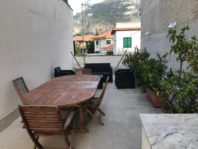 a wooden table and chairs on a patio at Appartamento Trilocale Mondello in Mondello