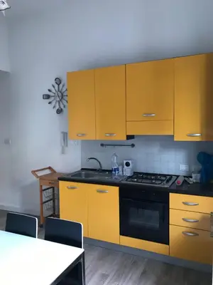a kitchen with yellow cabinets and a stove at Appartamento Trilocale Mondello in Mondello
