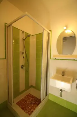 a green bathroom with a shower and a sink at Appartamento Trilocale Mondello in Mondello