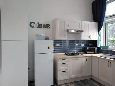 a kitchen with white cabinets and a white refrigerator at Casina Blu in Palermo