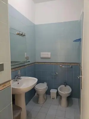 a bathroom with a sink and a toilet and a mirror at Casa delle Sirene in Isola delle Femmine