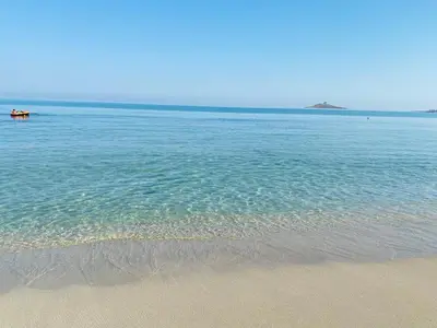 a beach with a boat in the water at Casa delle Sirene in Isola delle Femmine