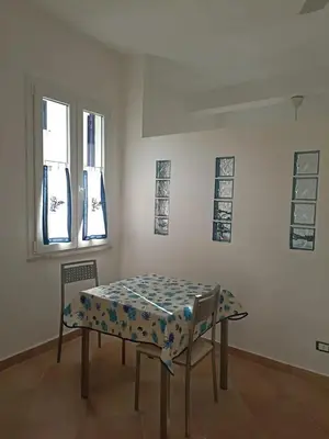 a room with a table and two chairs and windows at Casa delle Sirene in Isola delle Femmine