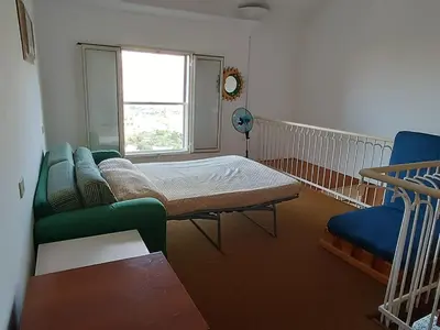 a room with a bed and a couch and a window at La Casa Del Nonno in Monreale