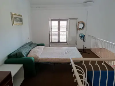 a bed in a room with a couch and a window at La Casa Del Nonno in Monreale