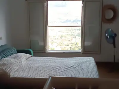 a bedroom with a bed and a large window at La Casa Del Nonno in Monreale