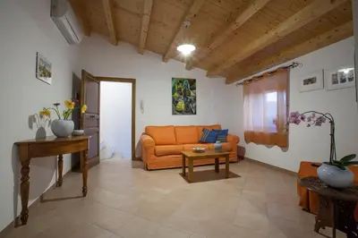 a living room with an orange couch and a table at Vito nel Baglio in Scopello