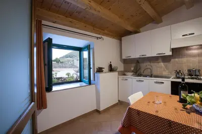 a kitchen with a table and a window at Vito nel Baglio in Scopello