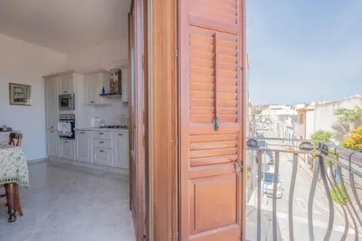 a wooden door in a kitchen with a balcony at A pochi passi dal mare in San Vito lo Capo