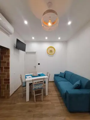 a living room with a blue couch and a table at Colle del Re Sicily in Partinico