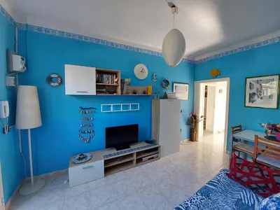 a living room with a blue wall at Salsedine Apartment in Palermo