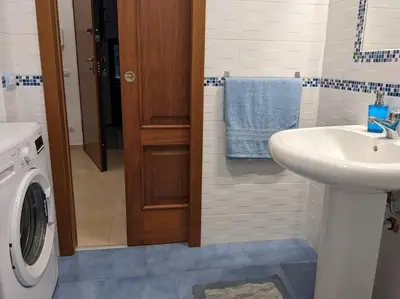 a bathroom with a sink and a washing machine at CASA 3T a Isola a 15 min dal centro di Palermo in Isola delle Femmine