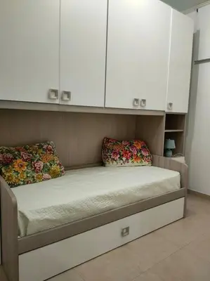 a bed in a room with white cabinets at CASA 3T a Isola a 15 min dal centro di Palermo in Isola delle Femmine