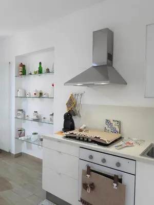 a kitchen with a stove top oven with a hood at A Casa di Eli Apartment in Palermo