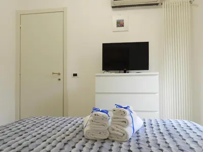 a bedroom with a bed with towels and a flat screen tv at A Casa di Eli Apartment in Palermo