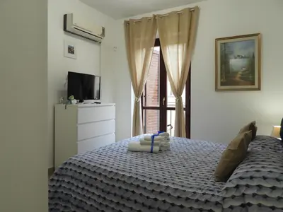 a bedroom with a bed and a tv and a window at A Casa di Eli Apartment in Palermo
