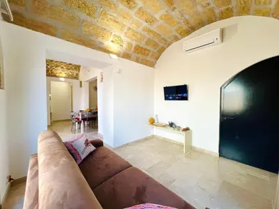a living room with a couch and a tv at Magaggiari Reef in Cinisi