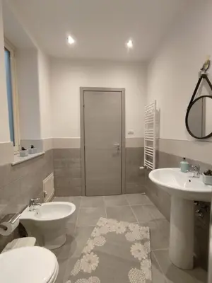 a bathroom with two sinks and a toilet and a mirror at Room Sixty One in Palermo