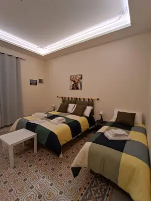 a bedroom with two beds and a table at Room Sixty One in Palermo