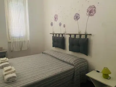 a bedroom with a bed with towels and flowers on the wall at Casa di Vale in Palermo