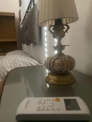 a lamp sitting on a table with a remote control at Casa di Vale in Palermo