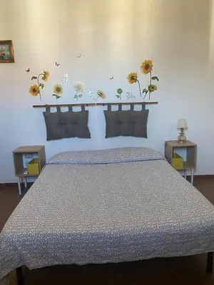 a bedroom with a bed with flowers on the wall at Casa di Vale in Palermo