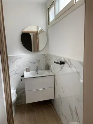 a white bathroom with a sink and a mirror at Marea in Palermo
