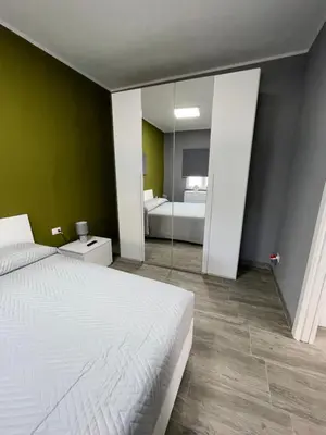 a bedroom with a white bed and a mirror at RESIDENCE GORDON in Carini