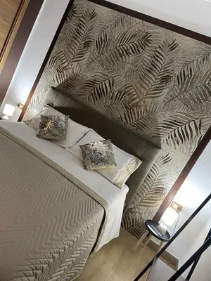 a bedroom with a large bed with a leaf patterned wall at RESIDENCE GORDON in Carini