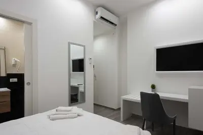 a bedroom with a bed and a desk and a mirror at Blanc Rooms in Palermo