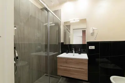a bathroom with a sink and a glass shower at Blanc Rooms in Palermo